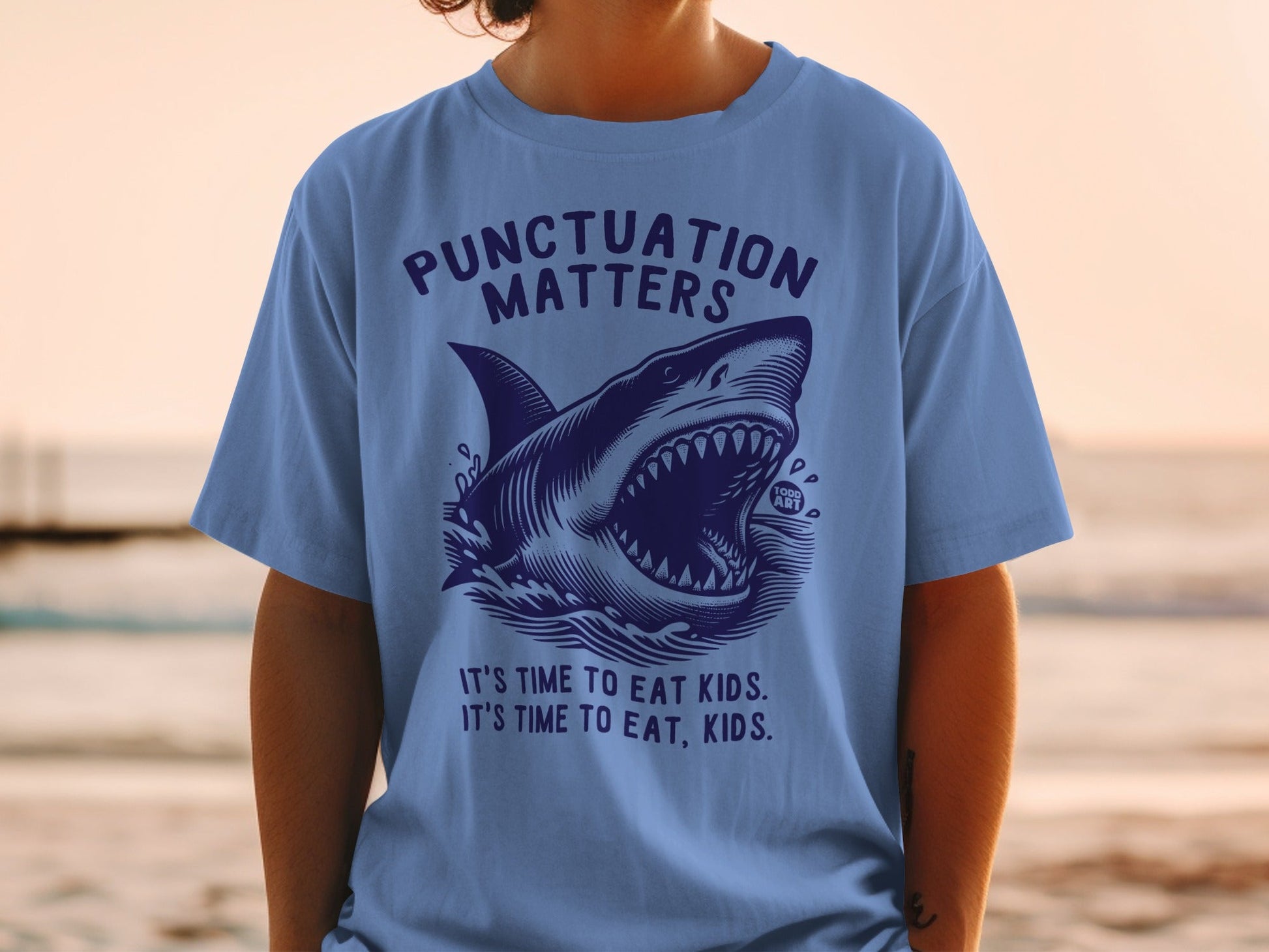 Blue t-shirt with shark graphic and "Punctuation Matters" text.