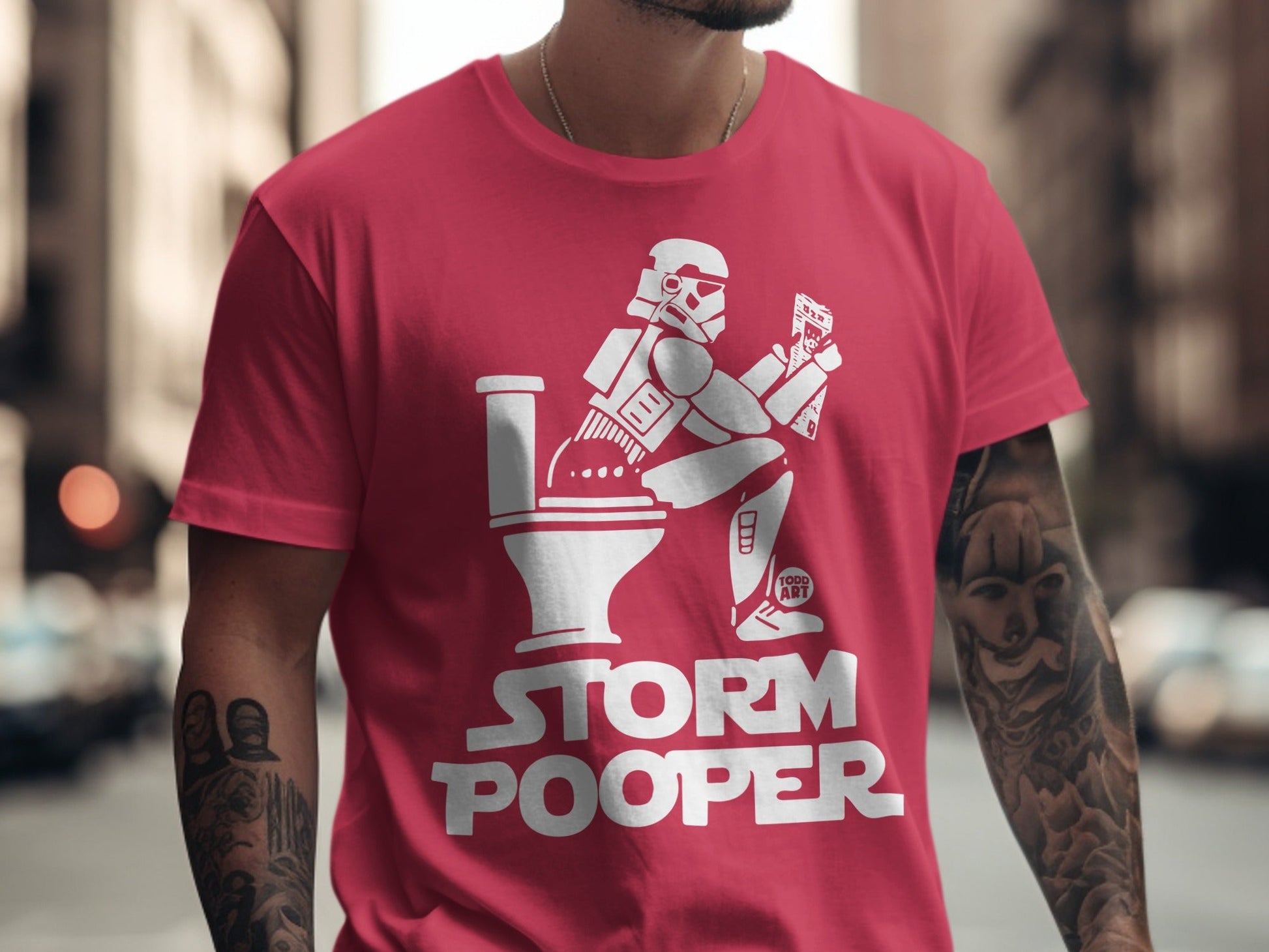 Red t-shirt with Stormtrooper on a toilet, reading, text reads "STORM POOPER".