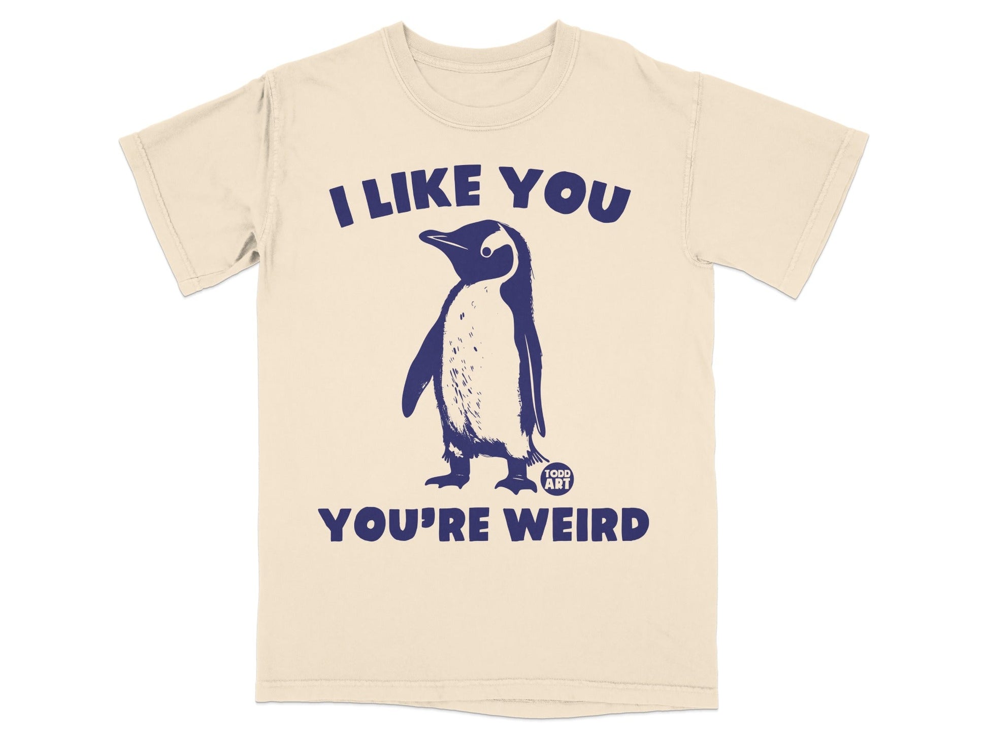 Cream t-shirt with a navy blue penguin and "I like you you're weird" text.