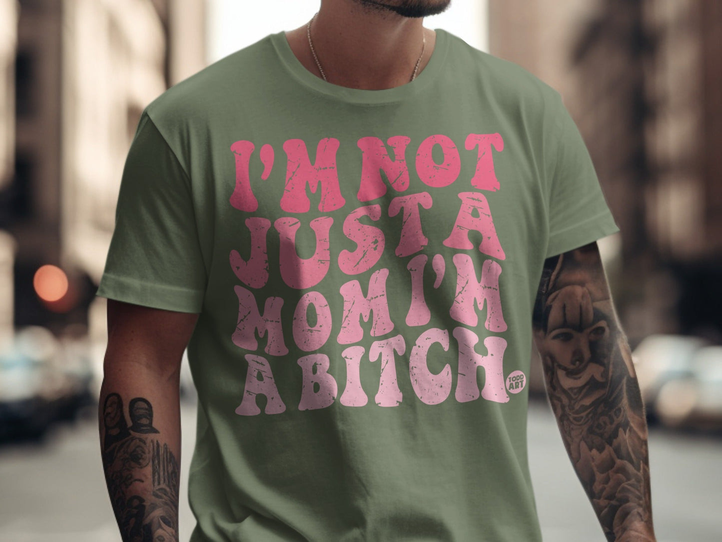 Green t-shirt with pink text reading "I'm not just a mom, I'm a bitch".