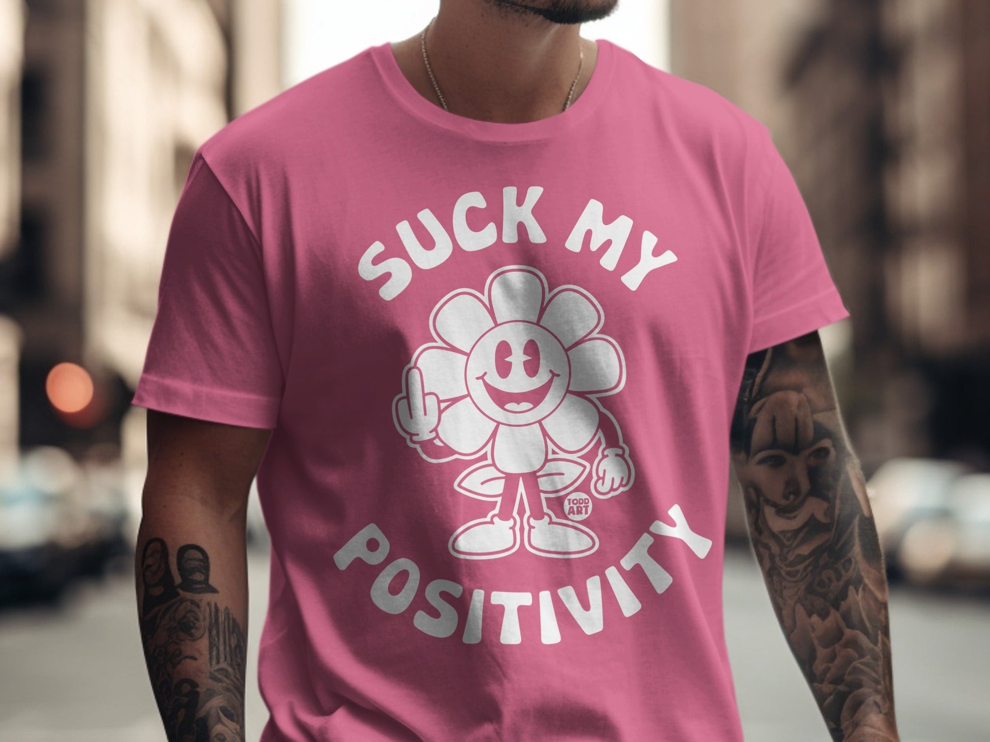 Pink t-shirt with cartoon flower giving middle finger and text "Suck My Positivity".