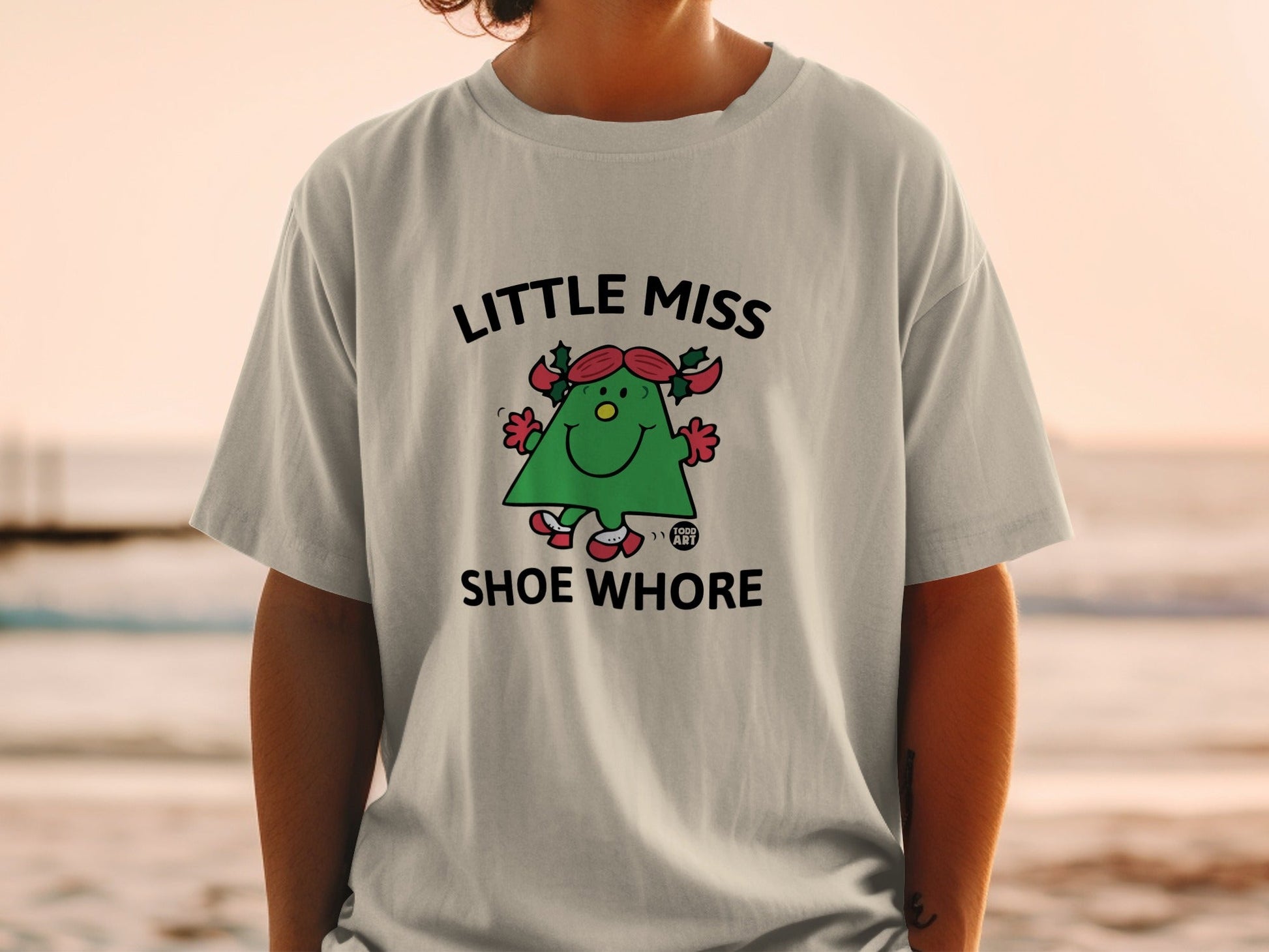 Little Miss Shoe Whore graphic t-shirt with animated character on light gray tee.