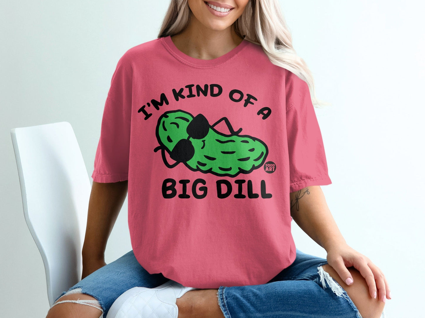 Pink t-shirt with a cartoon pickle wearing sunglasses and the text "I'M KIND OF A BIG DILL".