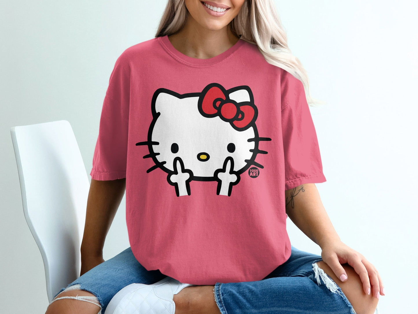 Hello Kitty graphic on a pink t-shirt worn by a woman.