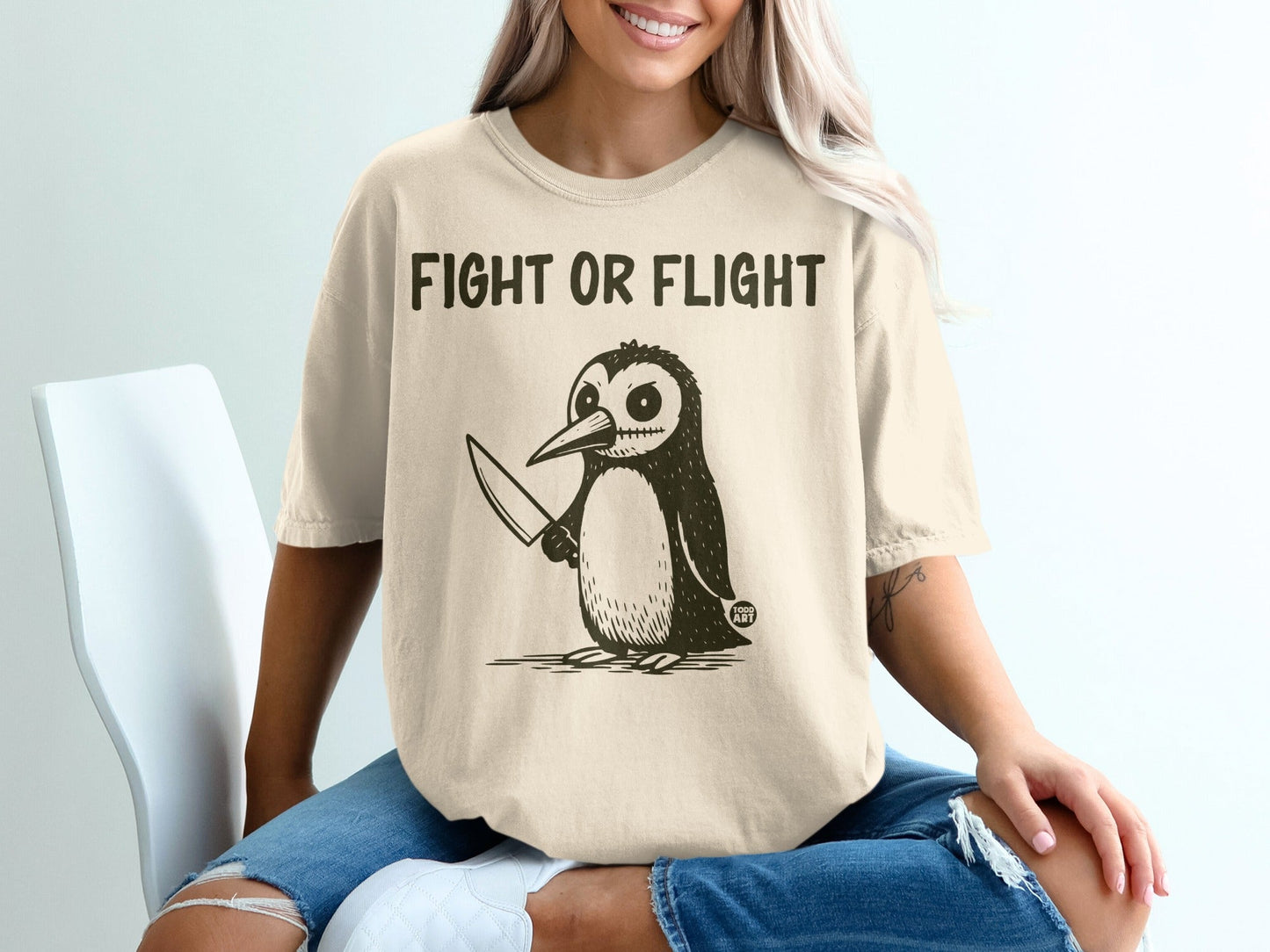 T-shirt with "FIGHT OR FLIGHT" and a cartoon penguin holding a knife.