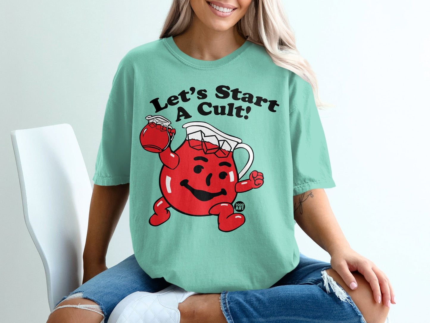 Teal t-shirt featuring cartoon Kool-Aid man with text "Let's Start a Cult!"
