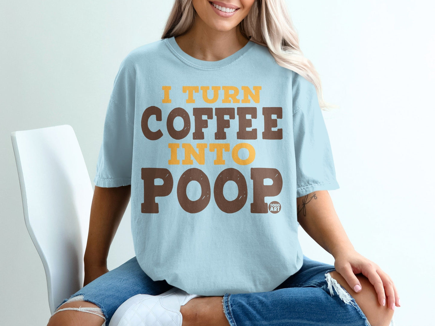 Light blue t-shirt with brown and yellow text: "I TURN COFFEE INTO POOP".