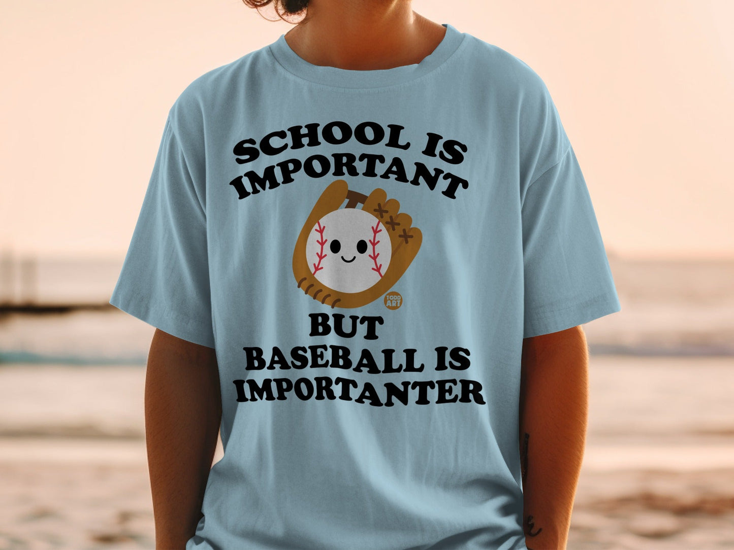 Light blue t-shirt with "School is important but baseball is importanter" text and baseball graphic.