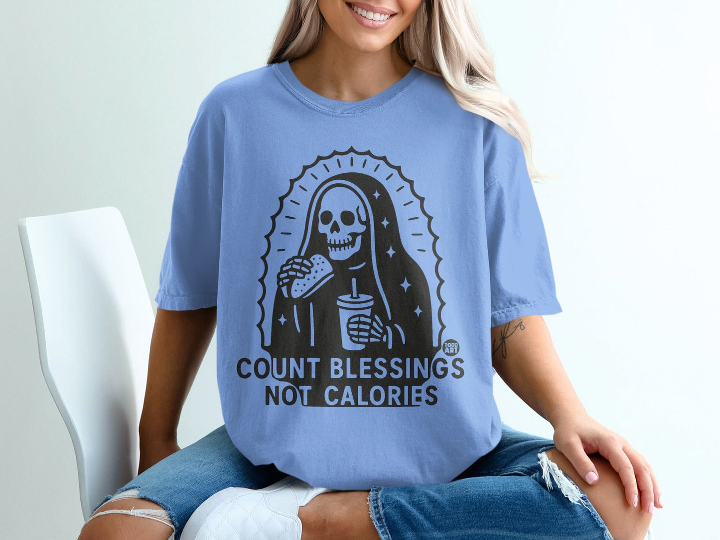 Light blue t-shirt with "COUNT BLESSINGS NOT CALORIES" and grim reaper eating burger graphic.