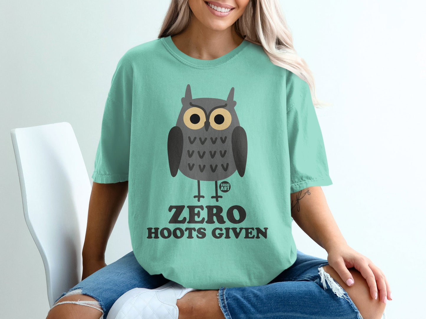 Teal t-shirt with a cartoon owl graphic and text "ZERO HOOTS GIVEN".