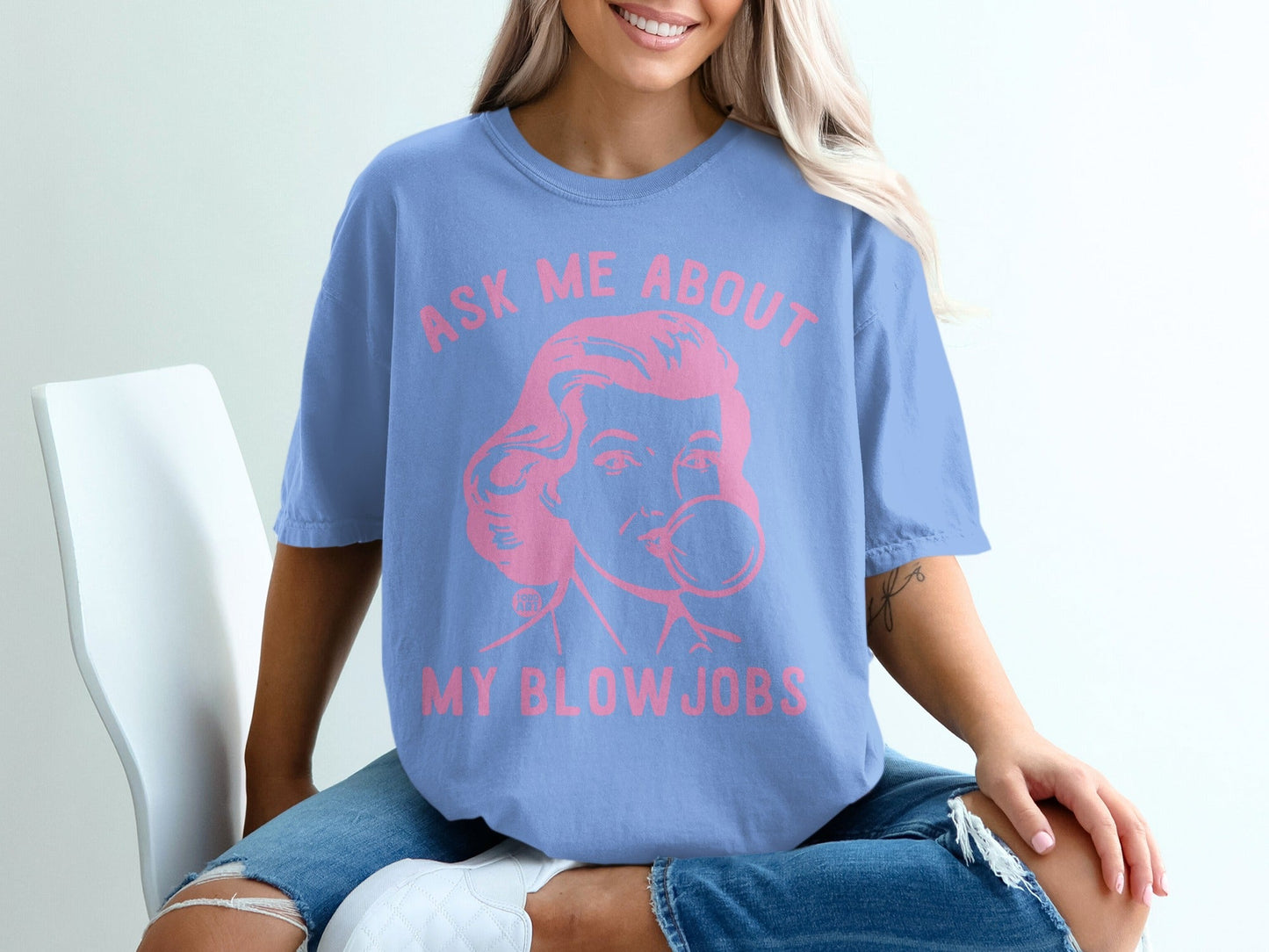 Woman wearing blue t-shirt with pink text: "Ask me about my blow jobs".