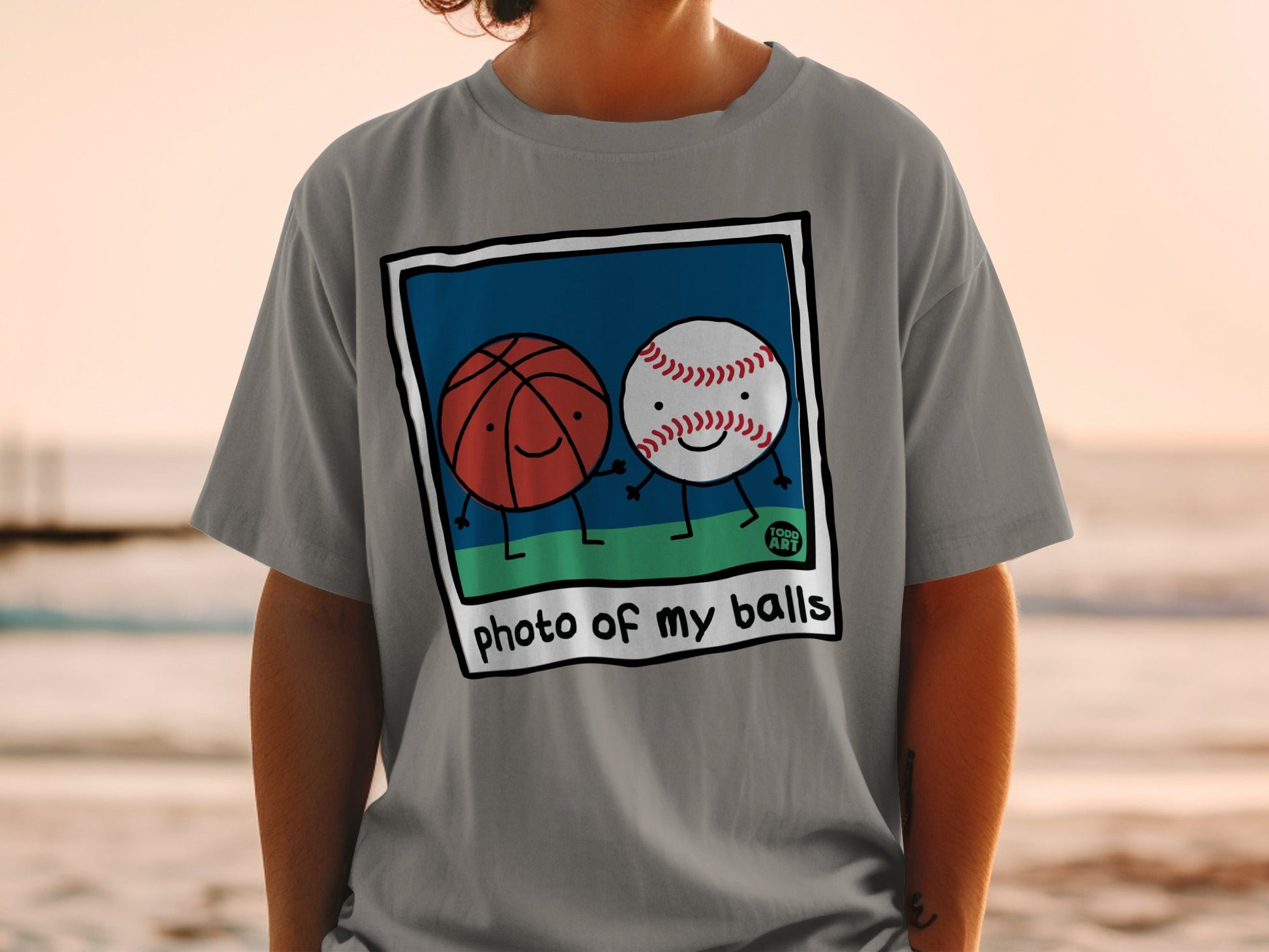 Two cartoon balls, basketball and baseball, holding hands on a grassy field.