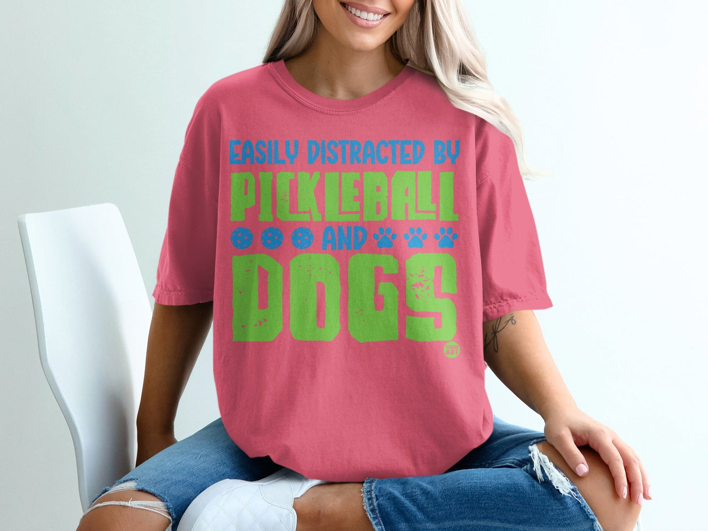 Pink t-shirt with "Easily Distracted by Pickleball and Dogs" text and paw prints.