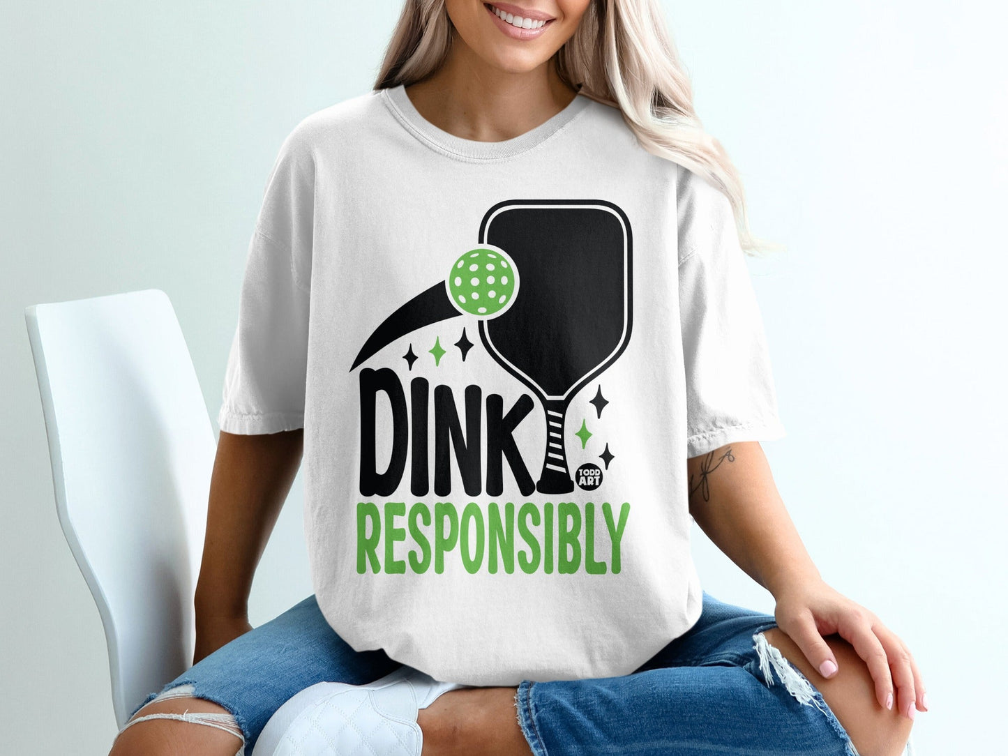 White t-shirt with "DINK RESPONSIBLY" and pickleball graphics.