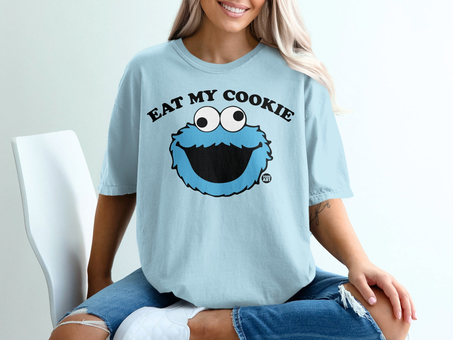 Light blue t-shirt with Cookie Monster graphic and "EAT MY COOKIE" text.