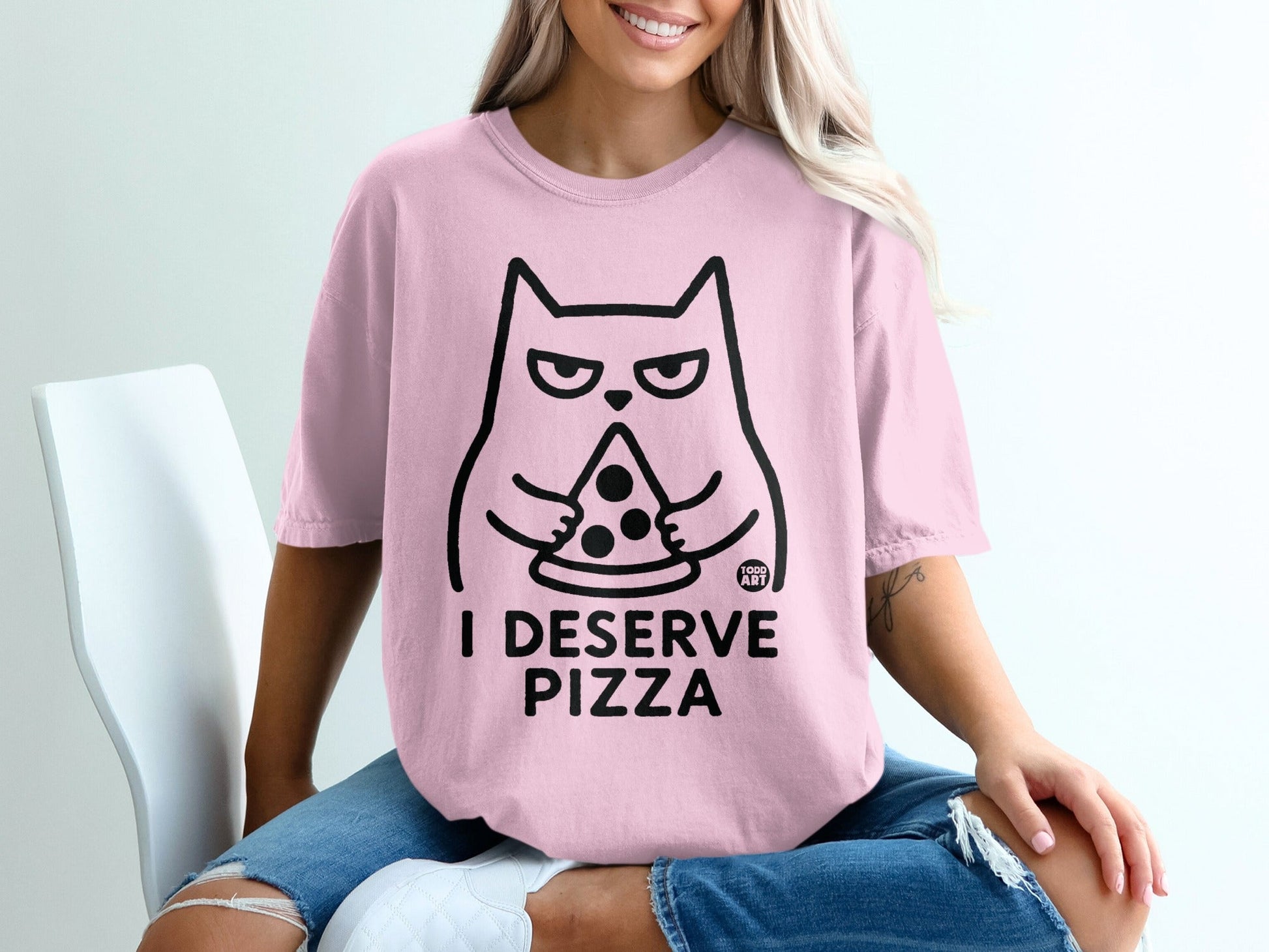 Pink t-shirt with black cat holding pizza and text "I DESERVE PIZZA".
