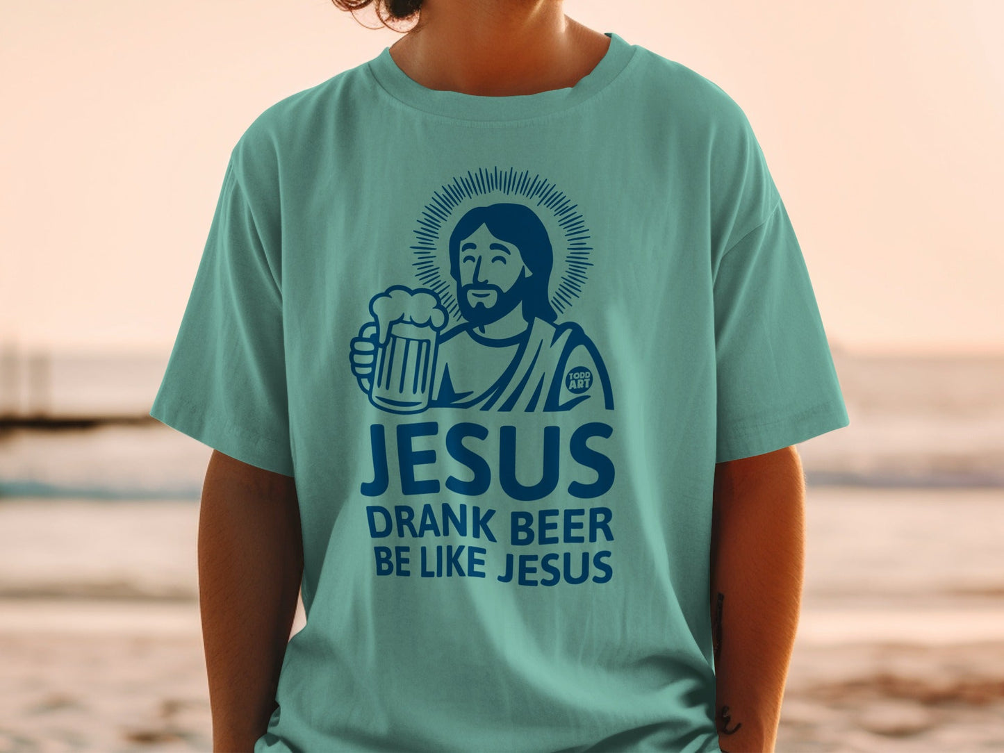 Teal t-shirt with graphic of Jesus holding a beer and text "JESUS DRANK BEER BE LIKE JESUS".