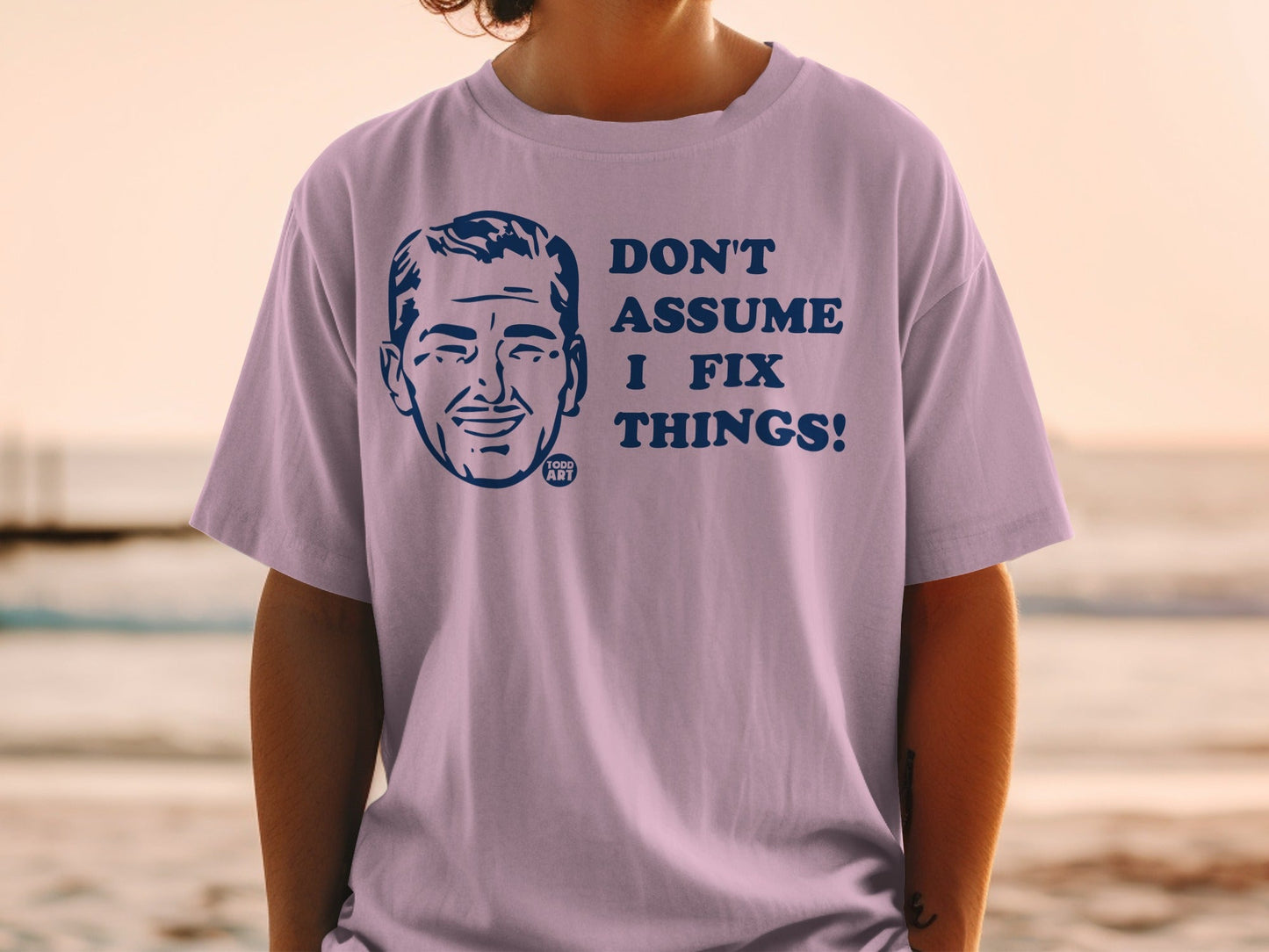 T-shirt with blue cartoon face and "Don't assume I fix things!" text.