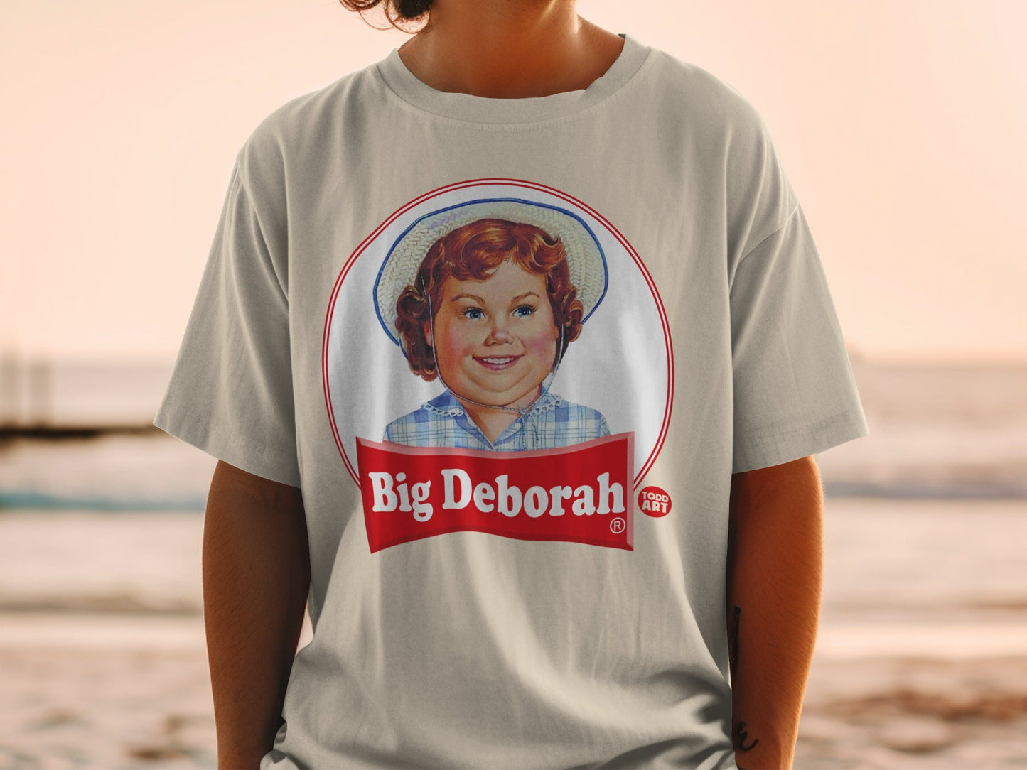 T-shirt with "Big Deborah" logo featuring a young girl with a hat.