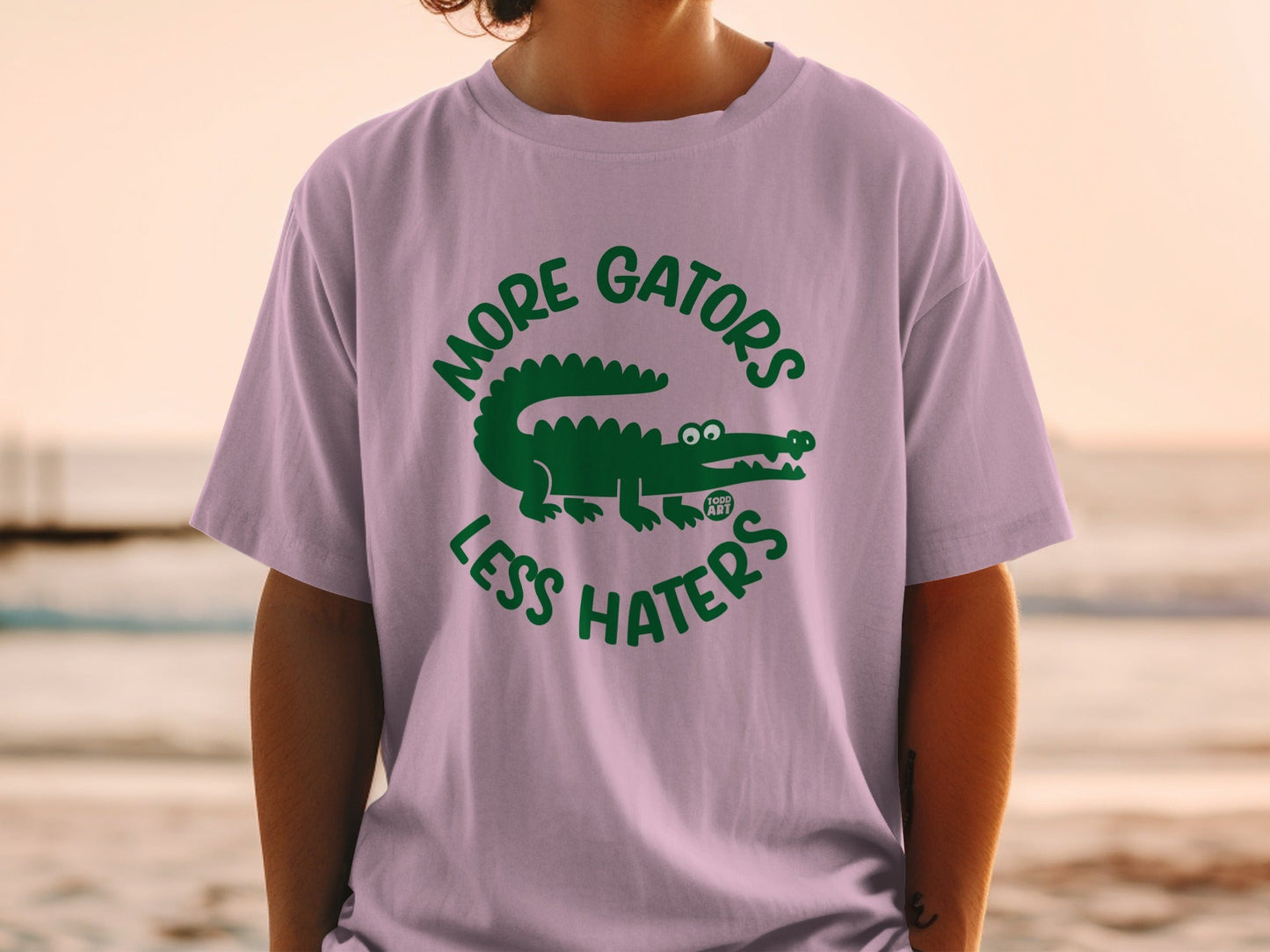 Purple t-shirt with green "MORE GATORS LESS HATERS" text and alligator graphic.