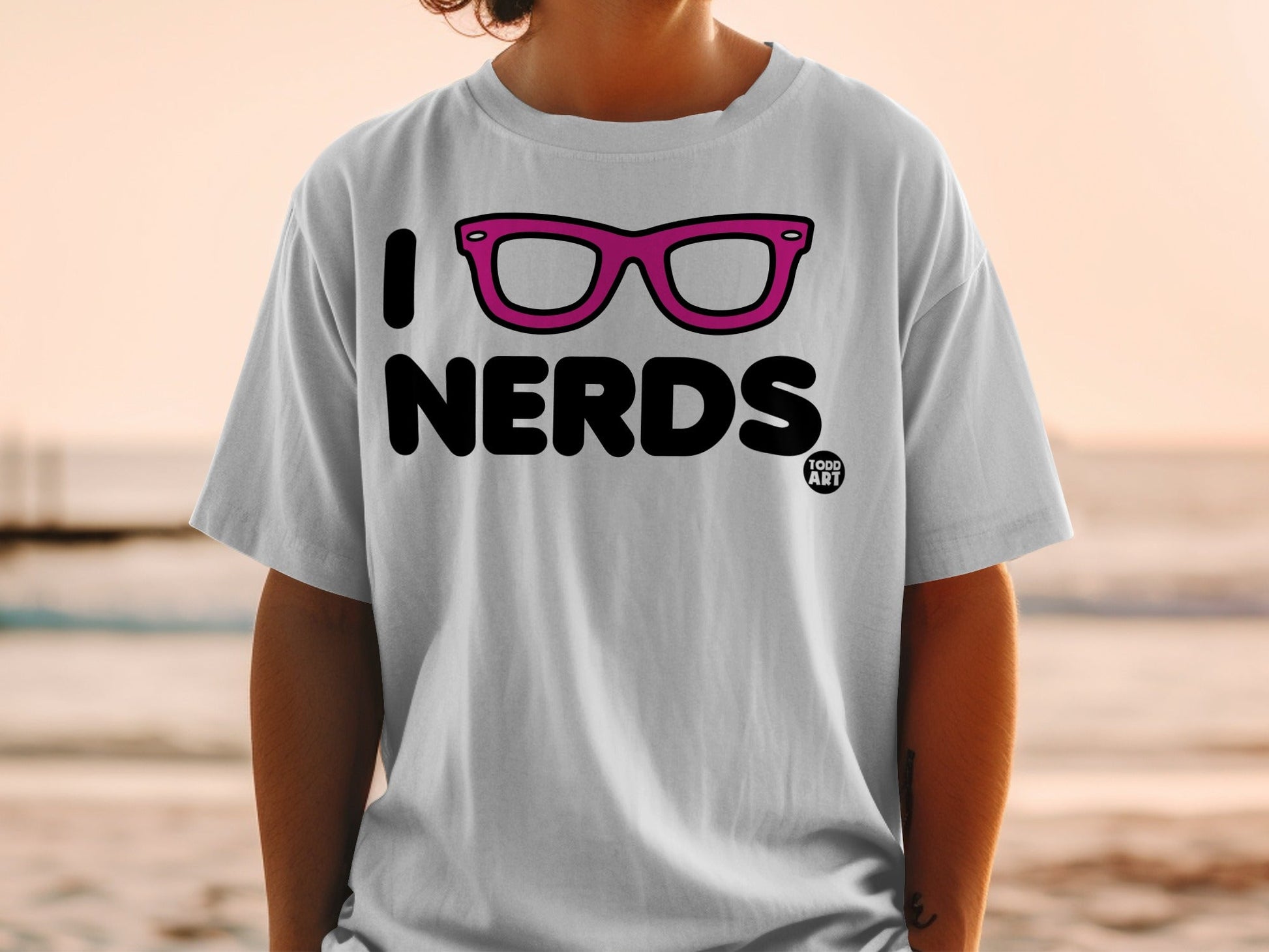 White t-shirt with "I [heart shape] NERDS" text and pink glasses.