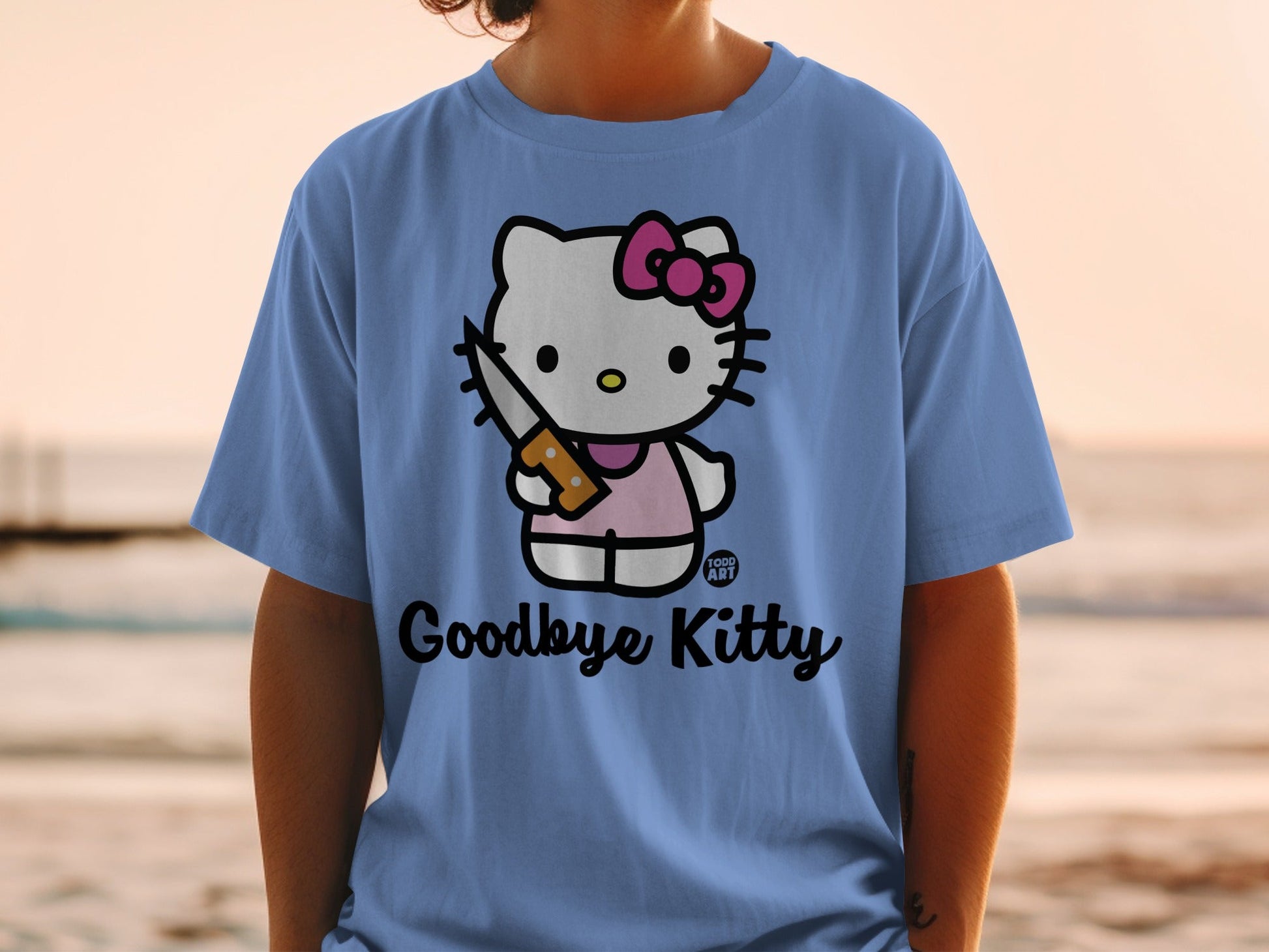 Blue t-shirt with Hello Kitty holding a knife, text reads "Goodbye Kitty".