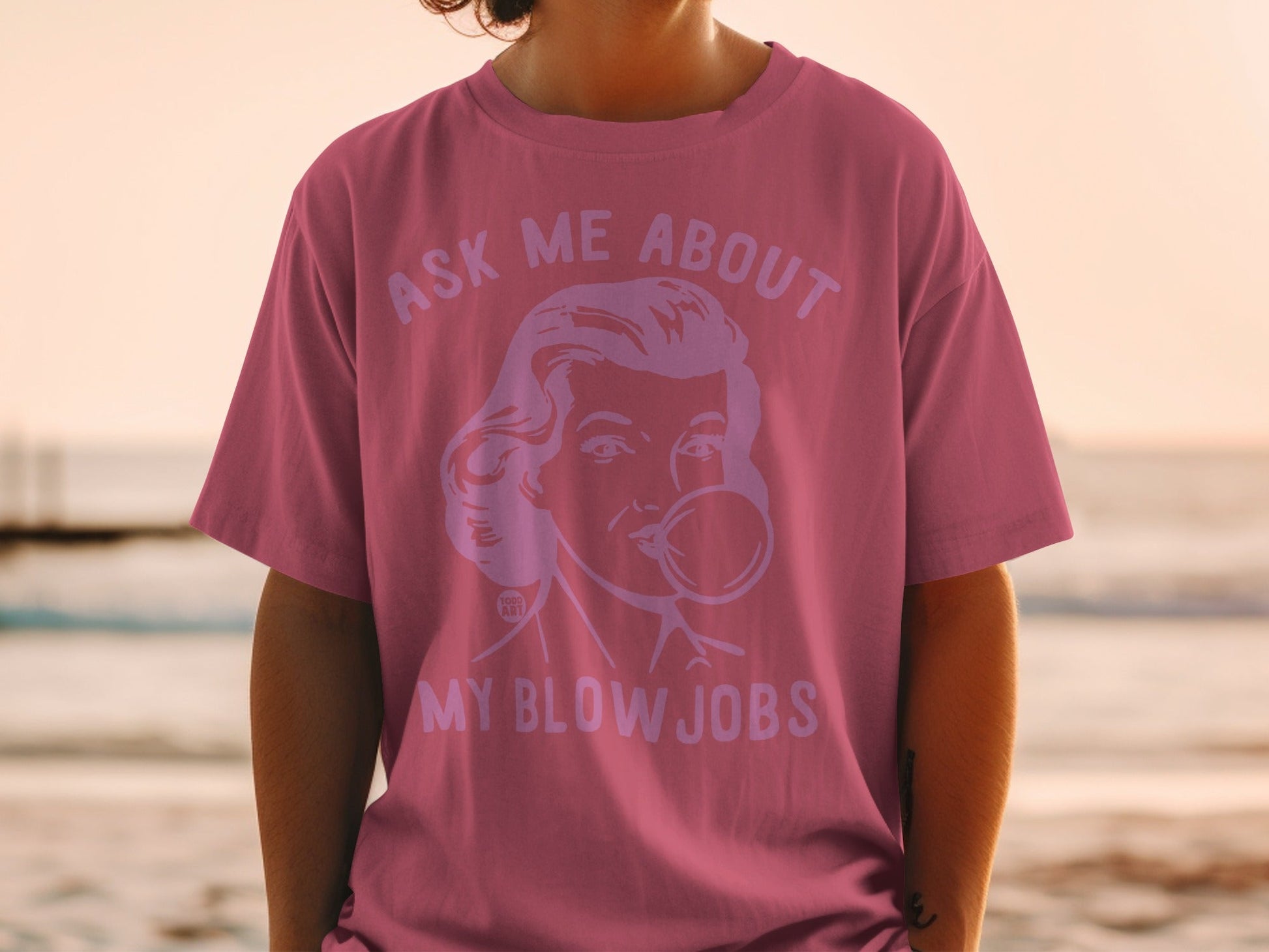 Pink t-shirt with Marilyn Monroe graphic and text "ASK ME ABOUT MY BLOW JOBS".