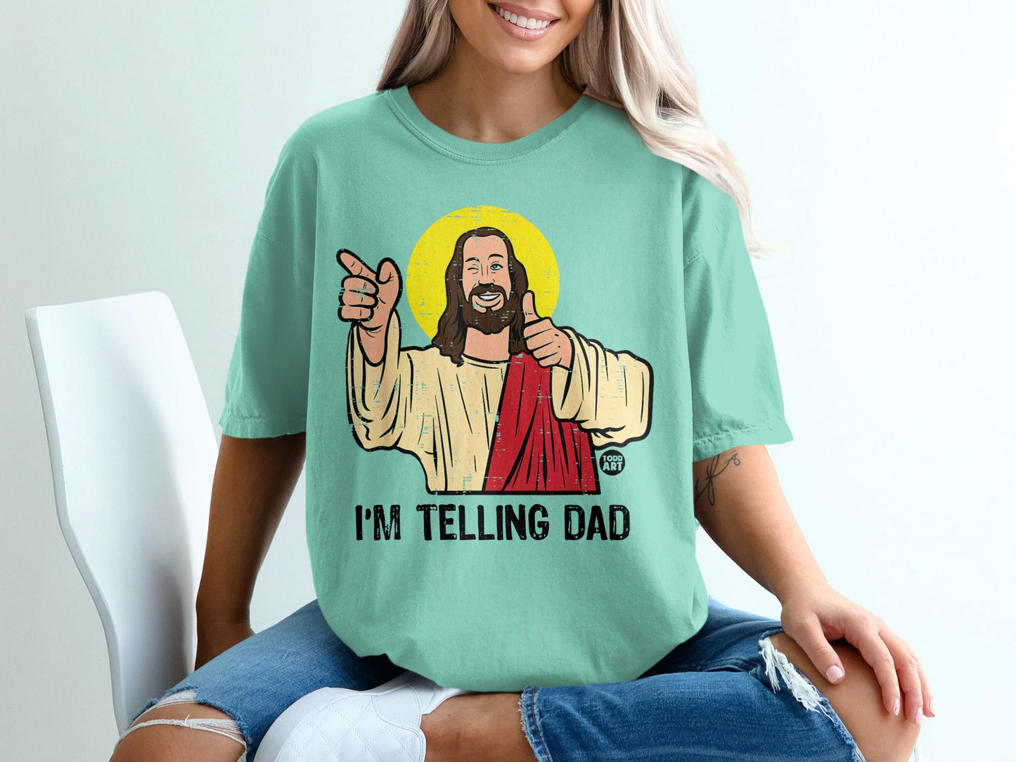 Teal t-shirt with Jesus graphic and "I'M TELLING DAD" text.