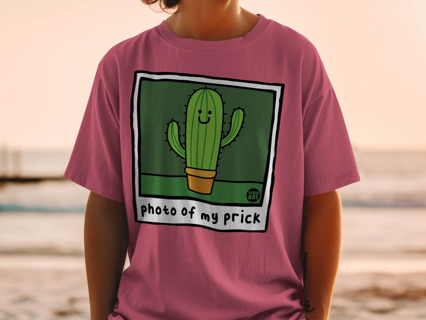 Pink t-shirt with a cartoon cactus wearing sunglasses.