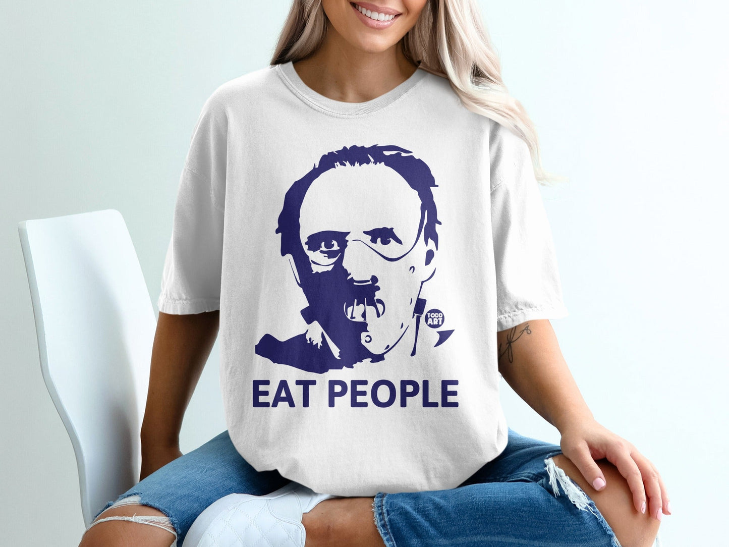 White t-shirt with dark blue graphic of Hannibal Lecter and "EAT PEOPLE" text.