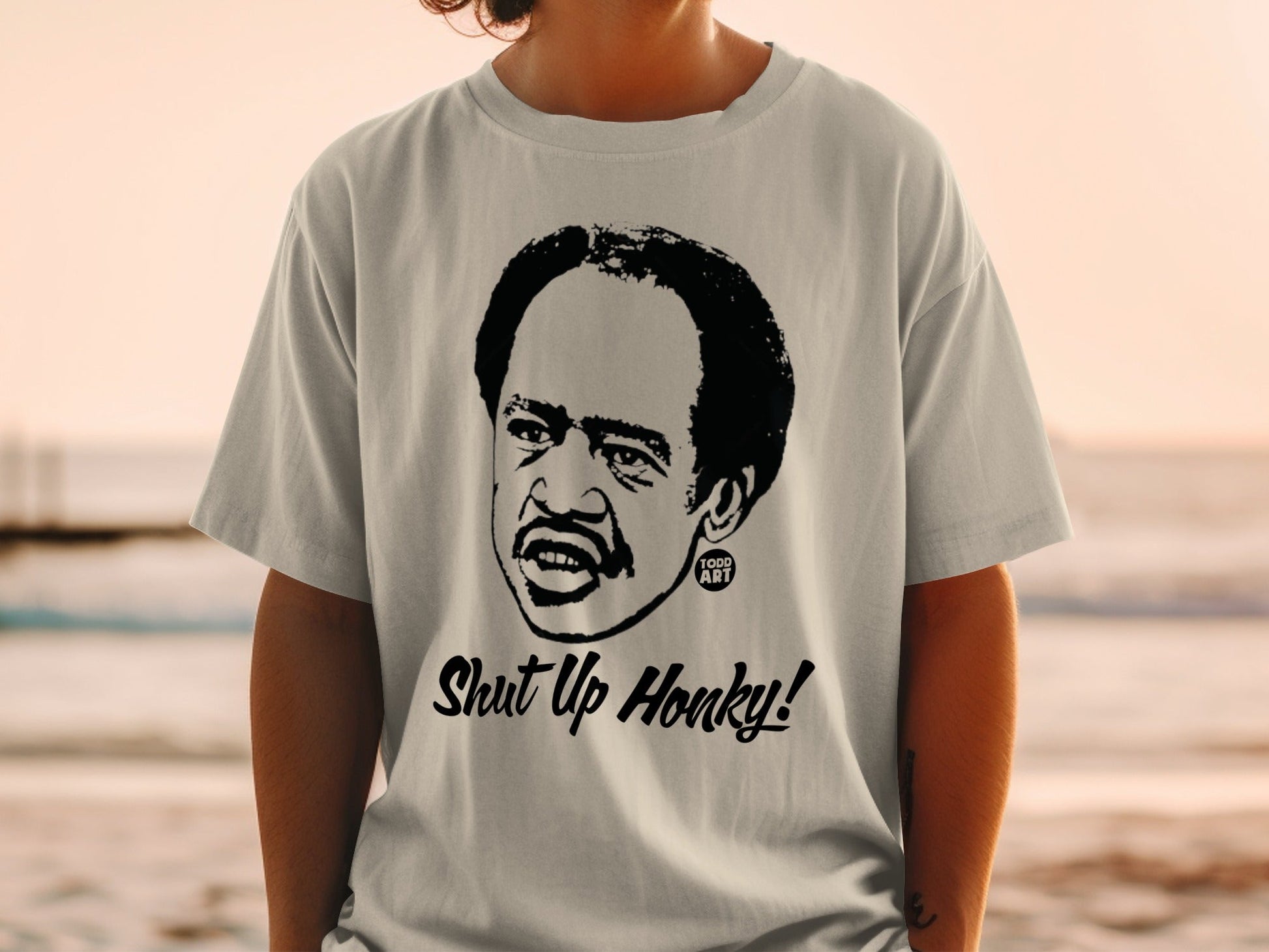 T-shirt with a black and white portrait and "Shut Up Honky!" text.