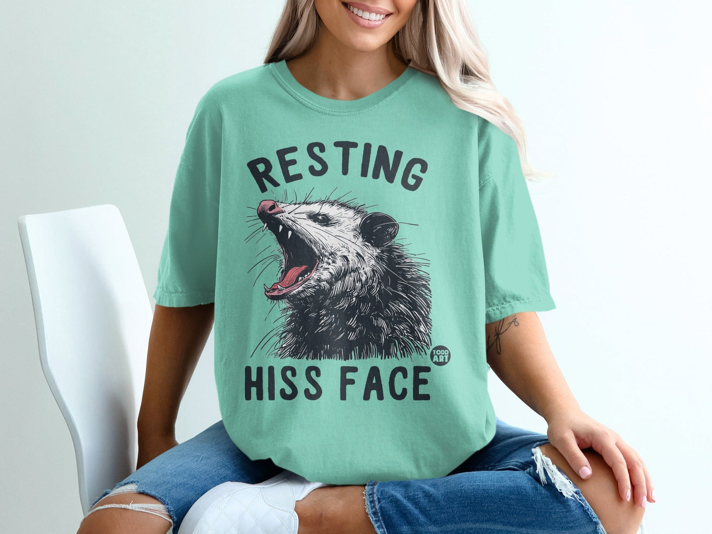 Opossum with mouth open and "RESTING HISS FACE" text on mint t-shirt.