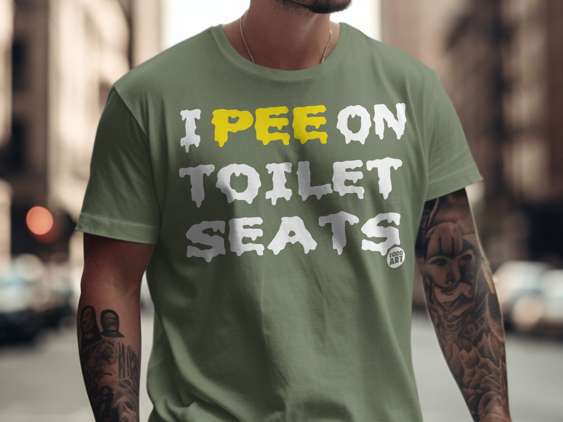 Olive green t-shirt with "I PEE ON TOILET SEATS" text in white and yellow.