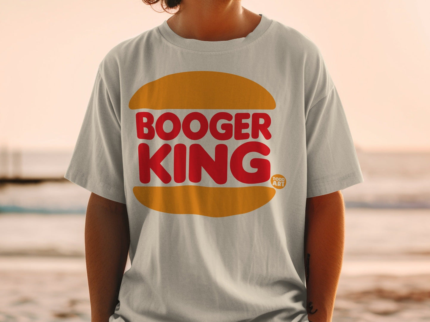 White t-shirt with red "Booger King" text inside an orange bun shape.