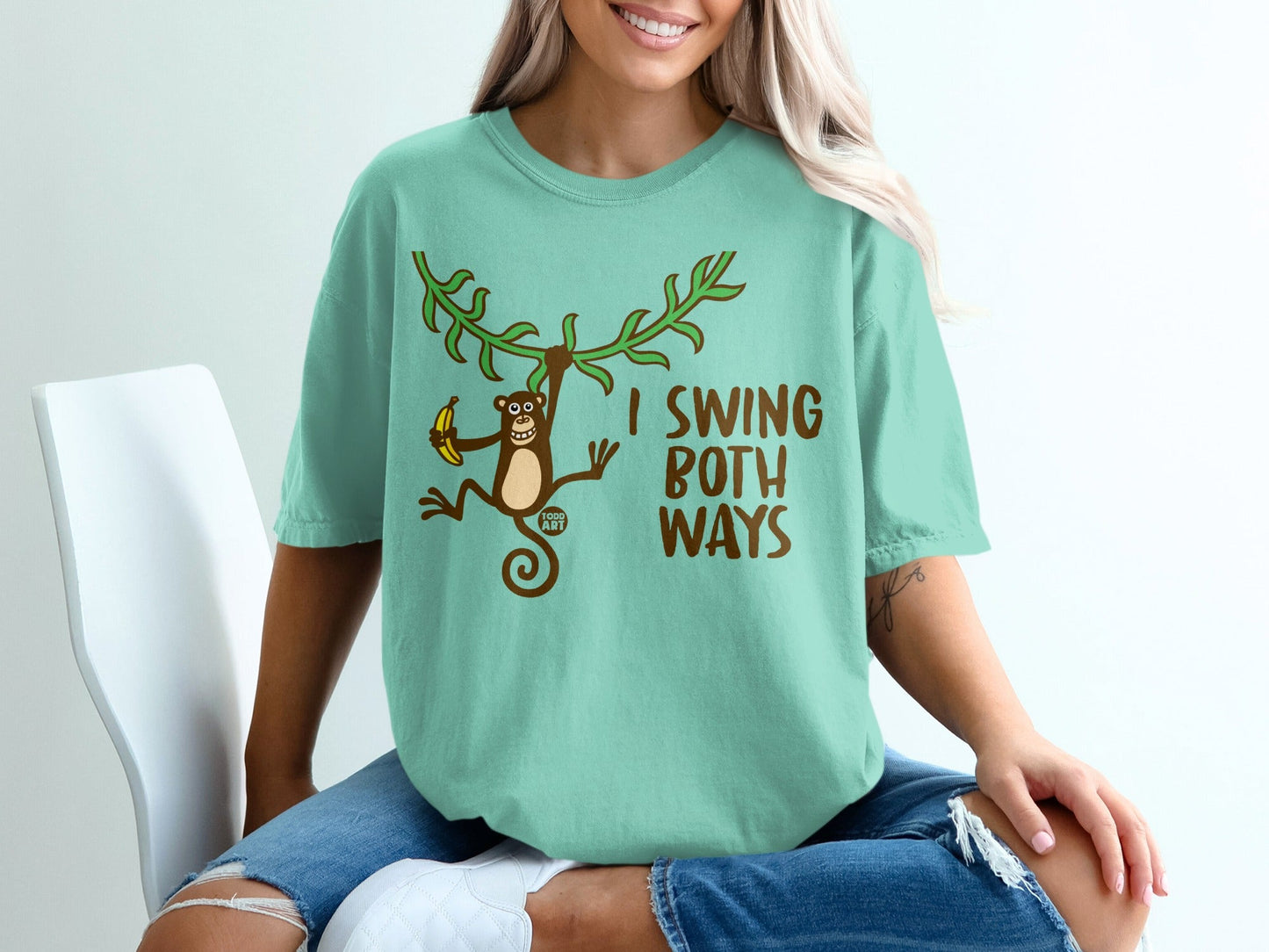 Teal t-shirt with monkey swinging on vine, holding banana, text I SWING BOTH WAYS.