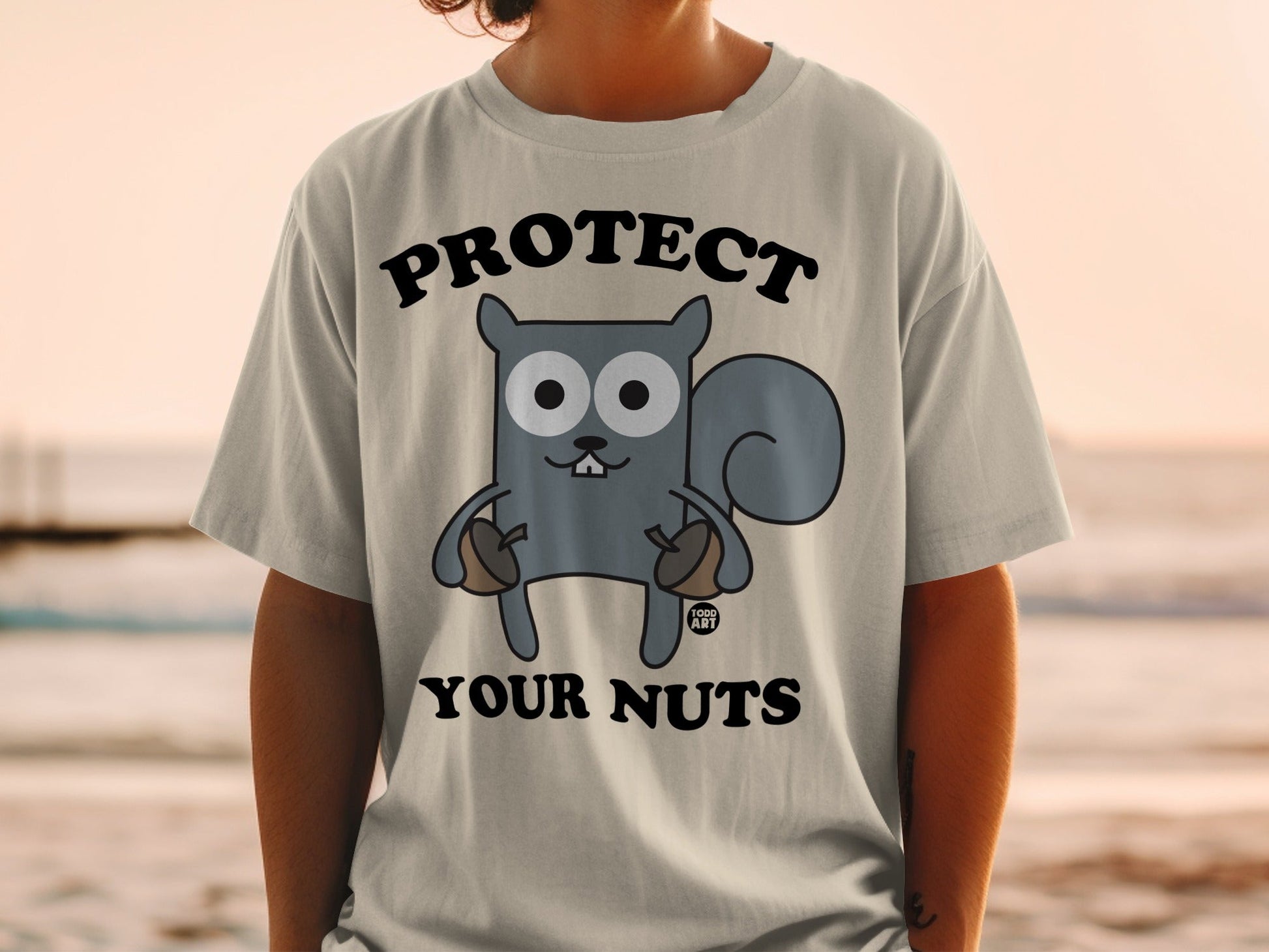 Cartoon squirrel with acorns wearing a t-shirt that says "PROTECT YOUR NUTS".
