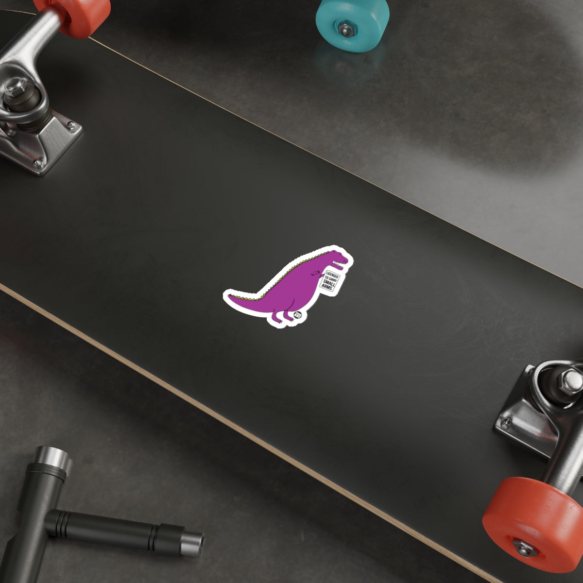 Purple Dinosaur Sticker on Black Skateboard Deck