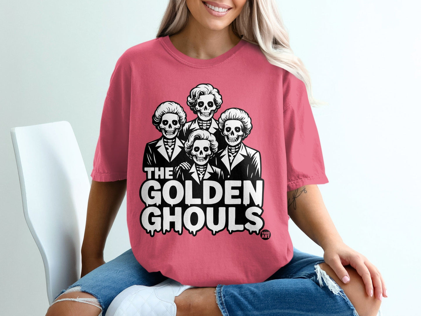 Pink t-shirt with "The Golden Ghouls" text and skeleton portraits.