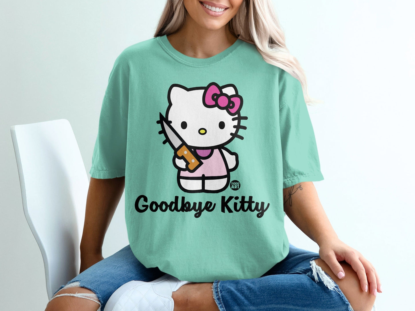 Teal t-shirt with Hello Kitty holding a knife, text "Goodbye Kitty".