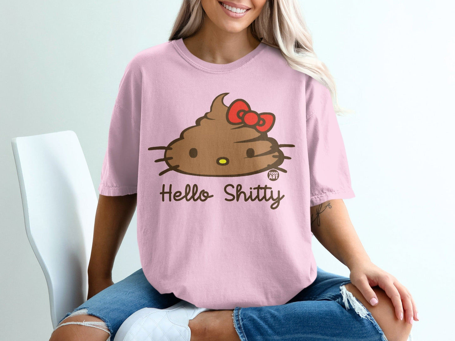 Pink t-shirt with a brown smiling poop emoji, red bow, and "Hello Shitty Food Art" text.