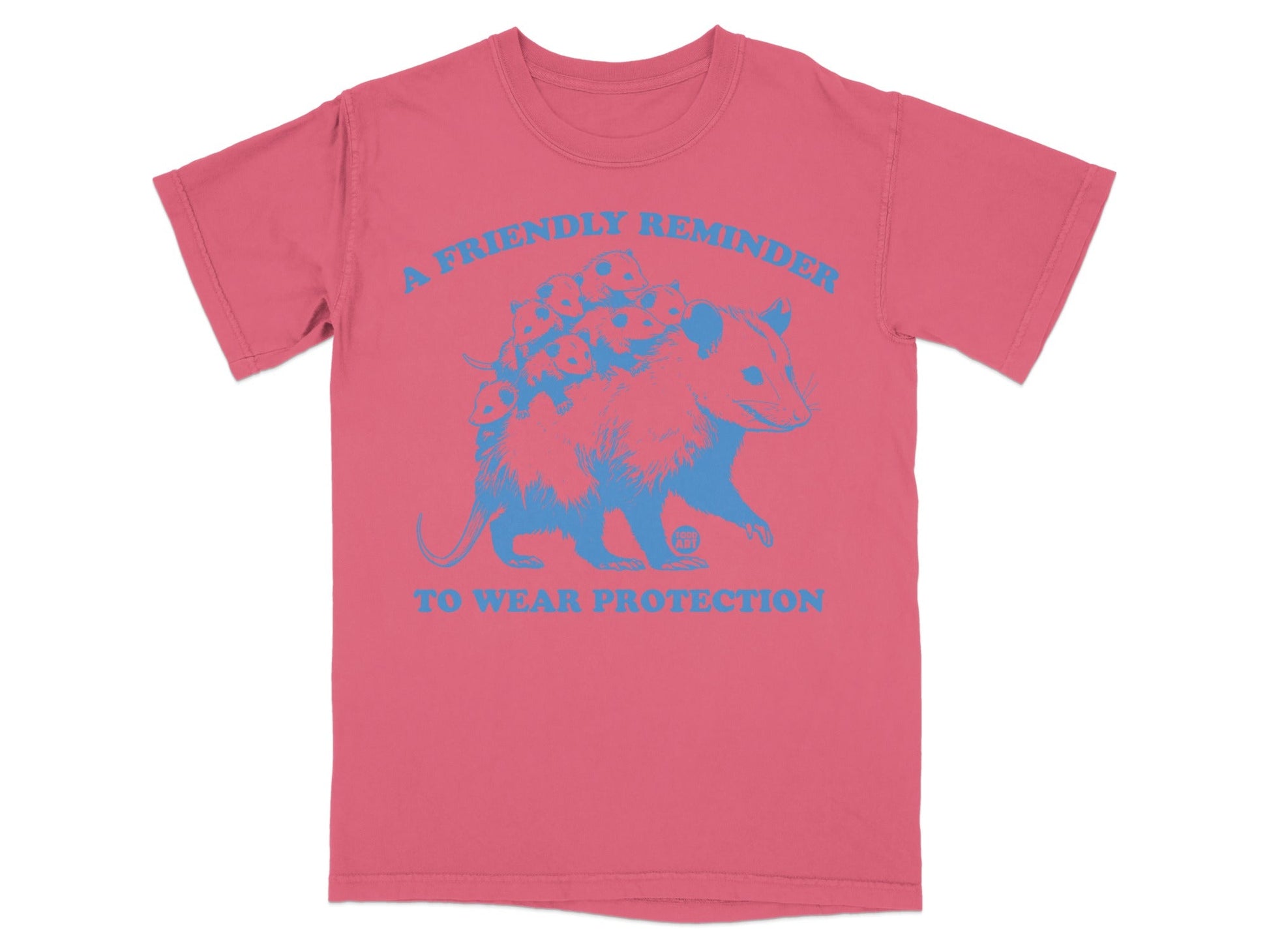 Pink t-shirt with blue graphic of an opossum and text "A FRIENDLY REMINDER TO WEAR PROTECTION".