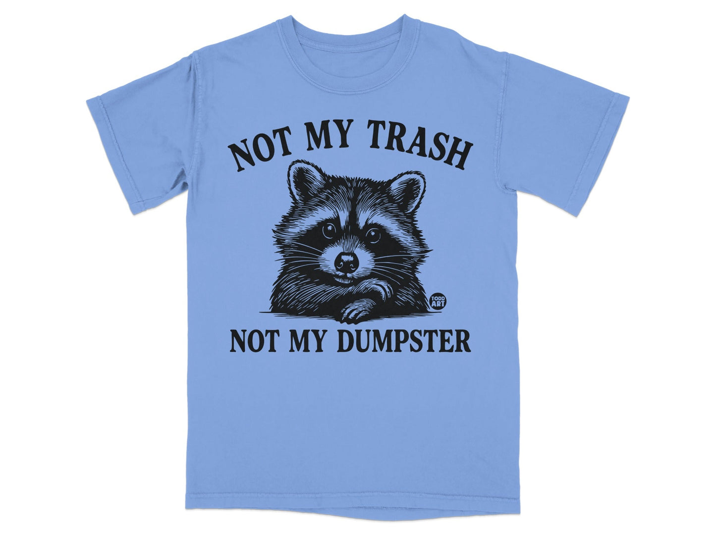 Light blue t-shirt with raccoon graphic and text "NOT MY TRASH NOT MY DUMPSTER".