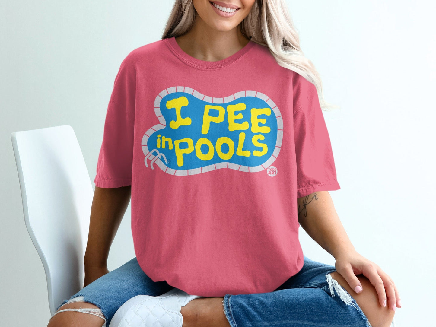 Pink t-shirt with "I PEE IN POOLS" text in a pool shape.