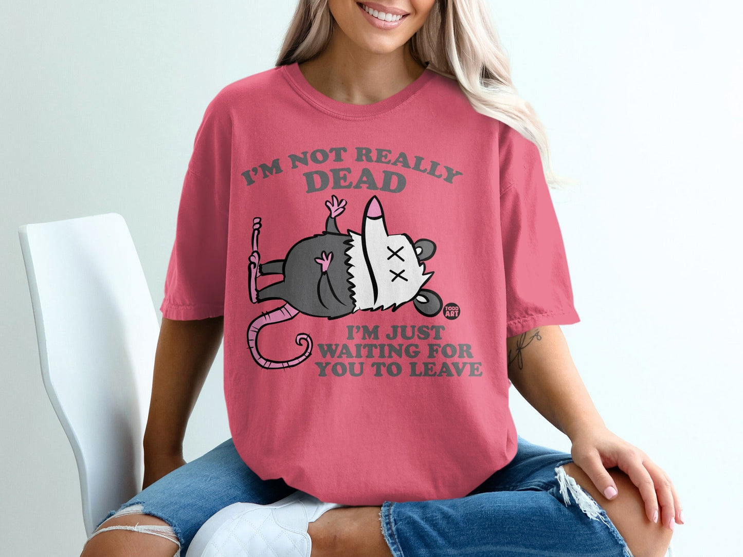 Pink t-shirt with cartoon opossum on it, text reads "I'm Not Really Dead, I'm Just Waiting For You To Leave".