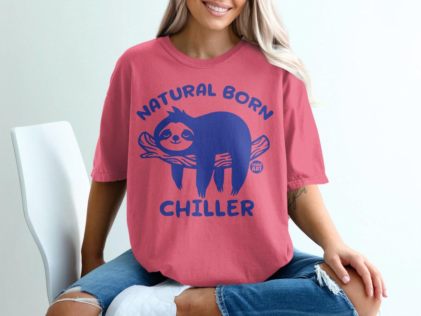Pink t-shirt with blue sloth graphic reading "Natural Born Chiller".
