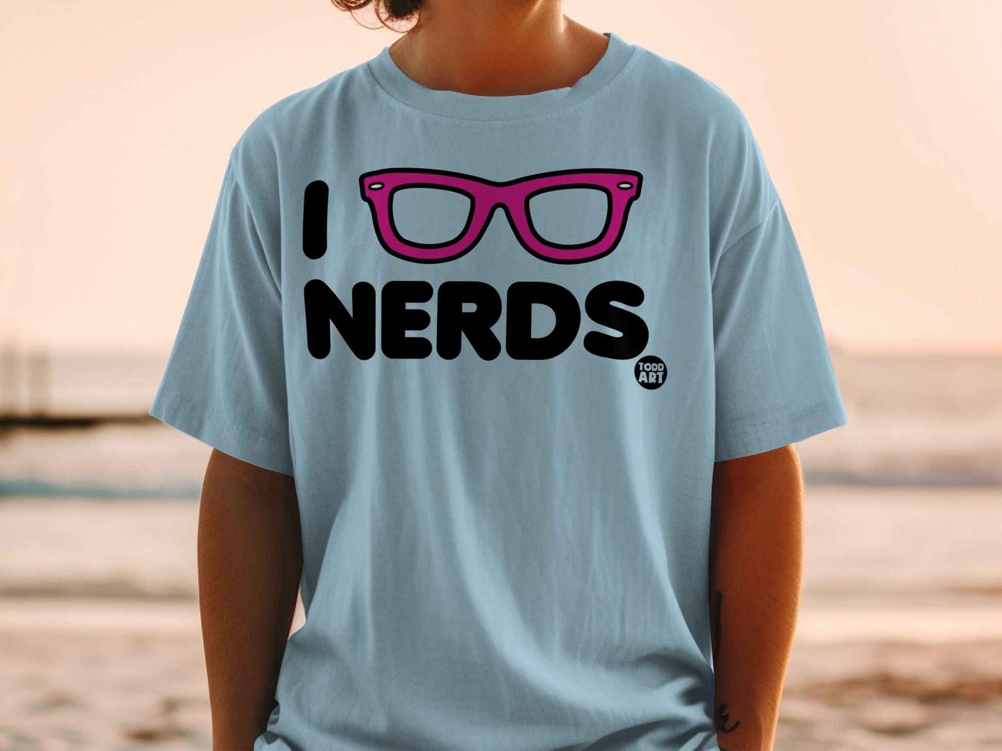 Light blue t-shirt with "I Nerds" and pink glasses graphic.