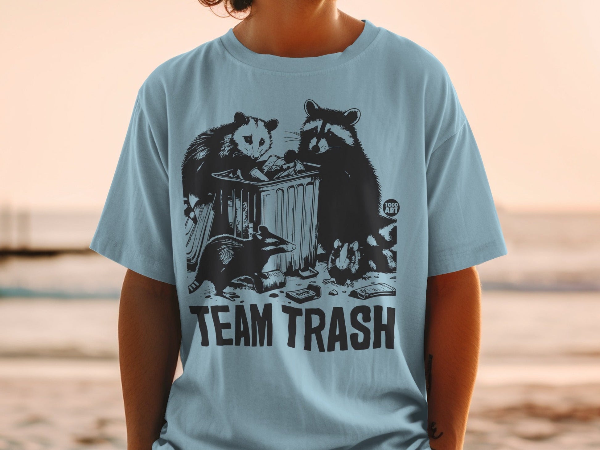 T-shirt with raccoons and an opossum raiding a trash can, with "TEAM TRASH" text.
