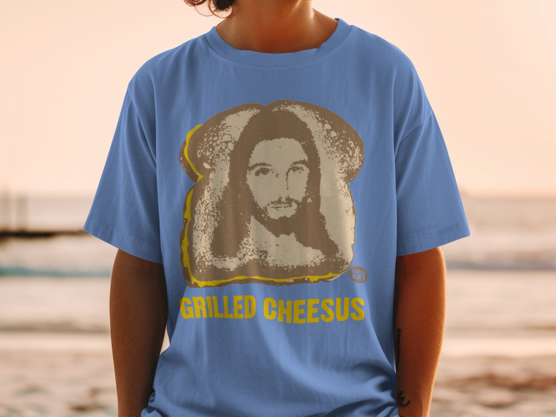 Blue t-shirt with grilled cheese sandwich and Jesus face graphic.