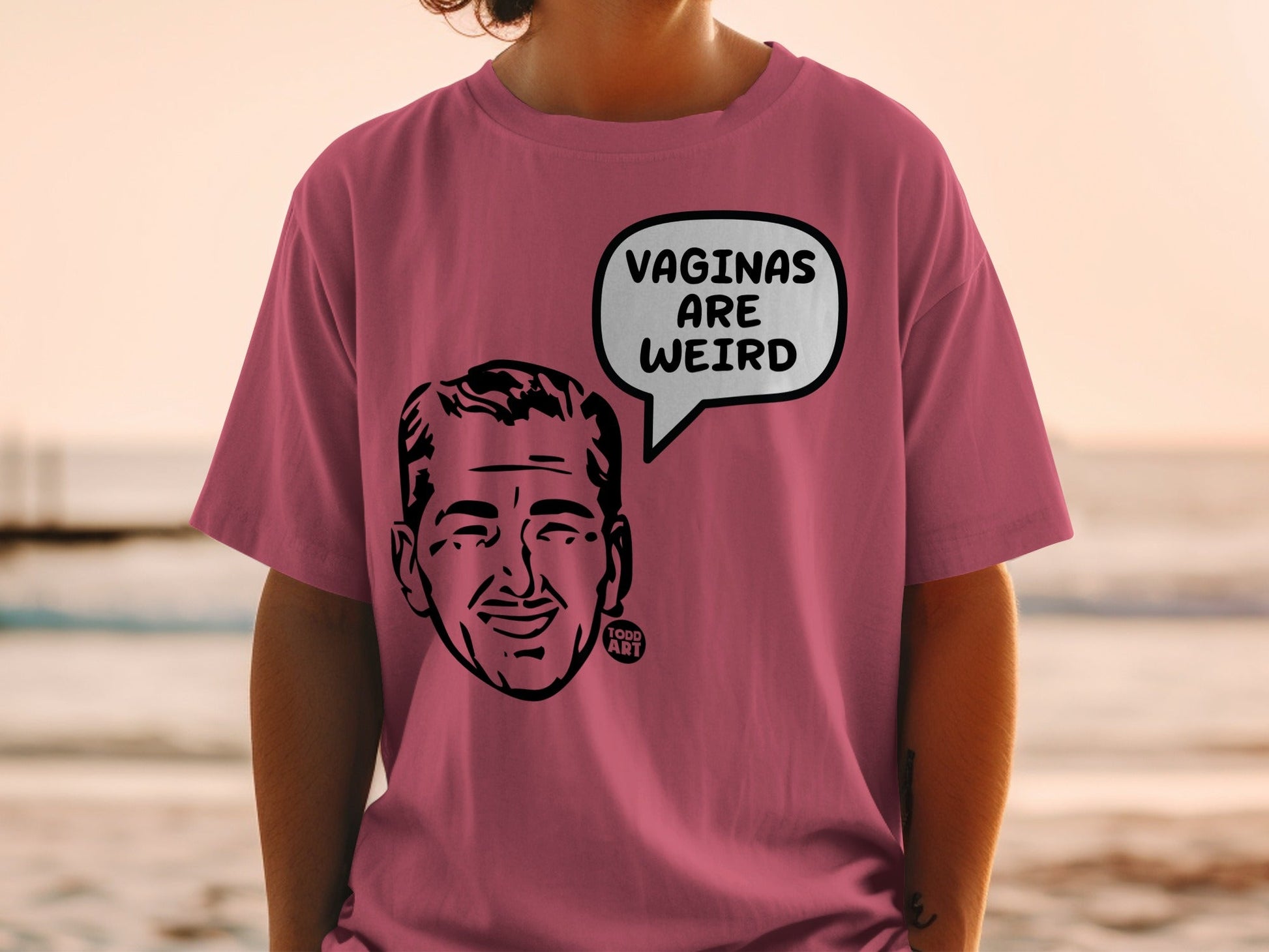 Pink t-shirt with a cartoon face and "Vaginas Are Weird" speech bubble.