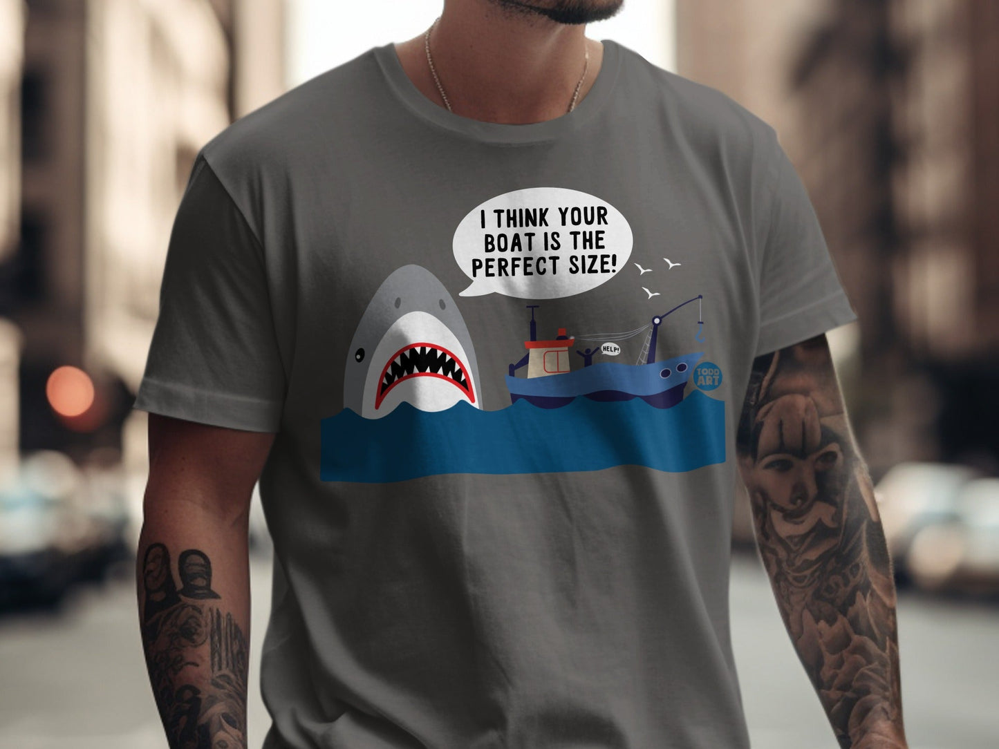 T-shirt with shark and boat graphic and text "I THINK YOUR BOAT IS THE PERFECT SIZE!".